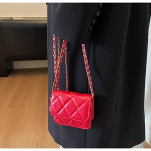 Détail du mini sac rouge matelassé avec finition brillante et chaîne dorée