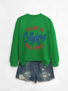 Dettaglio della felpa verde con stampa slogan e pantaloncini di jeans blu con strappi