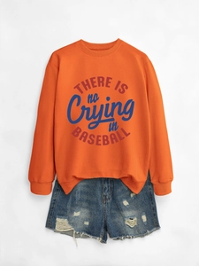 Flat lay di una felpa arancione con scritta baseball e pantaloncini di jeans strappati