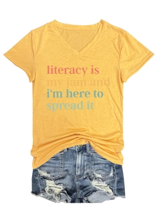 Flat lay of yellow V-neck T-shirt with literacy print and distressed denim shorts