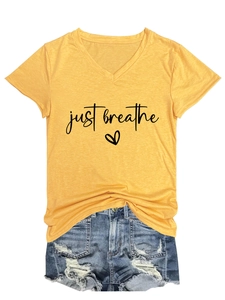 Detail of yellow V-neck T-shirt with just breathe heart print and distressed denim shorts