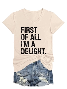 Flat lay of a beige V-neck t-shirt featuring First Of All I'm A Delight text with denim shorts
