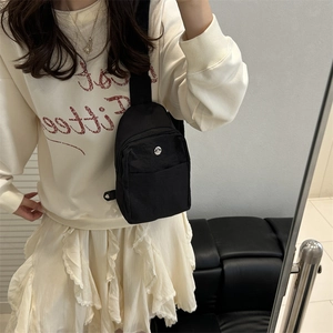 Sac de poitrine minimaliste en nylon noir avec sangle réglable et logo métallique M