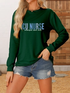 Close-up of ICU NURSE print on a dark green crewneck sweatshirt with soft fabric detail