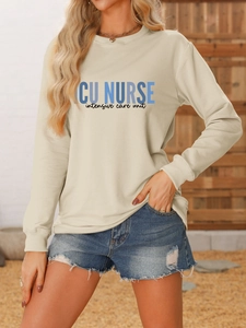 Close-up of ICU NURSE printed lettering on a beige long sleeve crewneck sweatshirt