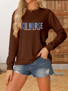Detailed view of ICU NURSE print on a brown crewneck sweatshirt worn with denim shorts