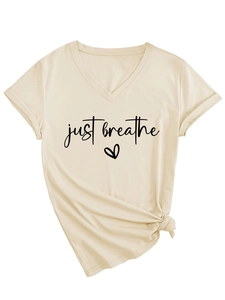 Detail of V-neck apricot T-shirt featuring just breathe print and side knot design