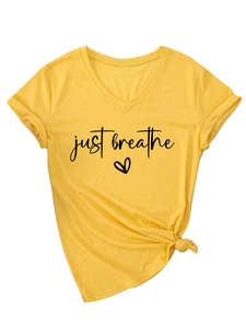 Detail view of yellow V-neck T-shirt with 'just breathe' text and knotted hem design