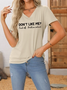 Gros plan sur un t-shirt beige à col V avec imprimé textuel et jean bleu délavé