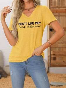 Détail d'un t-shirt moutarde à col en V avec impression graphique noire du slogan