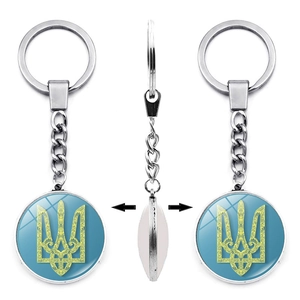 Three-sided view of a silver keychain with the Ukraine trident emblem on blue glass