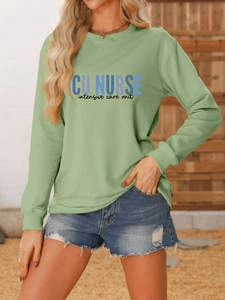 Detailed view of ICU NURSE text print on a sage green crewneck sweatshirt material