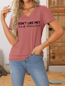 Détail d'un t-shirt col V rose poudré avec slogan et collier cœur sur mannequin