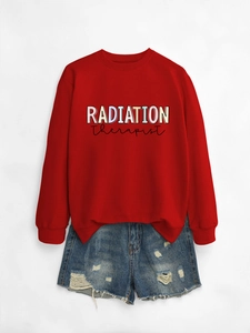 Detail showing red Radiation Therapist crewneck sweatshirt paired with distressed denim shorts