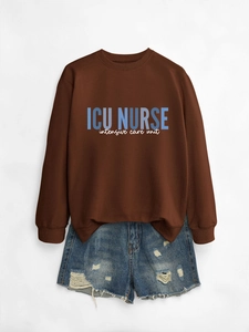 Close-up of ICU NURSE lettering on a dark brown crewneck sweatshirt and denim shorts