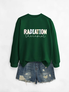 Detailed flat lay of green Radiation Therapist sweatshirt with distressed denim shorts
