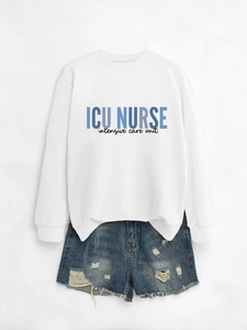 Flat lay of white ICU Nurse sweatshirt with blue distressed denim shorts on white background