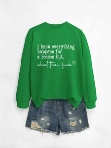 Flat lay of green crewneck sweatshirt with white slogan and distressed denim shorts