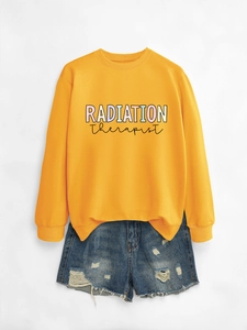 Flat lay of a yellow Radiation Therapist sweatshirt paired with distressed denim shorts