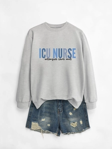Detailed flat lay of ICU NURSE sweatshirt with distressed denim shorts on white background