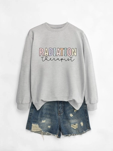 Flat lay of gray radiation therapist sweatshirt paired with distressed denim shorts