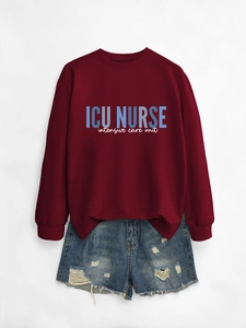 Close-up of ICU NURSE print on a burgundy crewneck sweatshirt with casual denim shorts