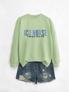 Detail of light green ICU NURSE sweatshirt paired with distressed denim shorts set