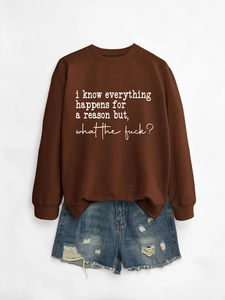 Close-up of brown crewneck sweatshirt with white handwritten text and ripped denim shorts
