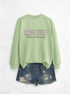 Flat lay of radiation therapist green sweatshirt with distressed denim shorts