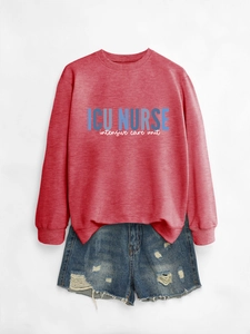 Flat lay of a red ICU Nurse sweatshirt paired with distressed denim shorts on grey background