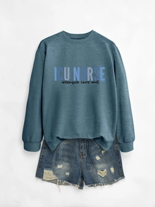 Flat lay of ICU NURSE crewneck sweatshirt with distressed ripped denim shorts