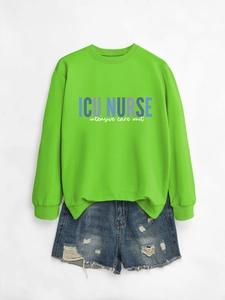 Detail of neon green ICU Nurse sweatshirt paired with distressed denim shorts