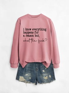 Detail of pink crewneck sweatshirt with black slogan text and distressed denim shorts
