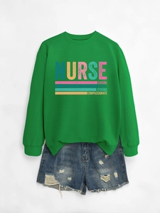 Detail of green nurse sweatshirt with caring loyal strong print and distressed denim shorts