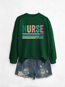 Flat lay of green nurse sweatshirt with caring loyal strong print and denim shorts