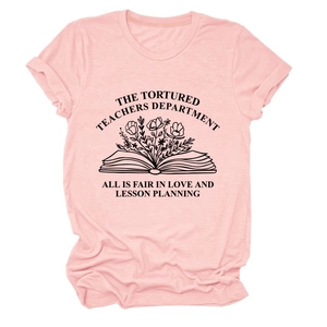 Detalle de camiseta rosa de algodón con diseño gráfico de libro y flores sobre fondo blanco