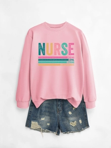 Close-up of pink nurse sweatshirt with caring strong text and ripped denim shorts