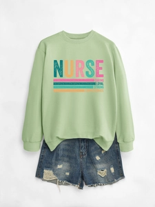 Detail of light green nurse sweatshirt with caring loyal strong print and denim shorts