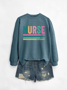 Close-up of nurse sweatshirt with caring loyal strong text and ripped denim shorts