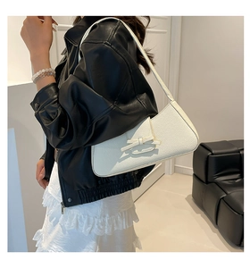 Primer plano de un bolso de hombro blanco en cuero texturizado con un lazo elegante