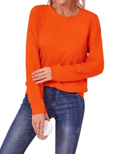 Detail of a bright orange crew neck sweatshirt with high-quality knitted fabric texture