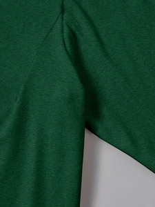 Close-up of durable stitching and dark green knitted fabric texture on long sleeve top
