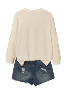 Detail view of cream long sleeve crewneck sweatshirt with distressed blue denim shorts