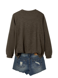 Close-up of a dark brown long sleeve crewneck top paired with frayed blue denim shorts