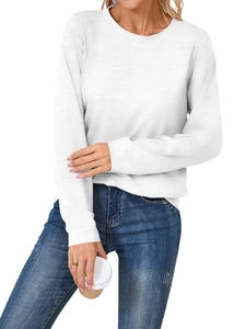 Detail of soft white long-sleeve crewneck top with ribbed cuffs and blue denim jeans