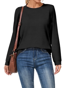 Detail of a loose-fit black long sleeve crewneck sweatshirt with dropped shoulders on a model