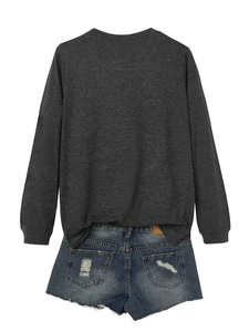 Detail of dark grey long sleeve t-shirt paired with distressed denim shorts on white background