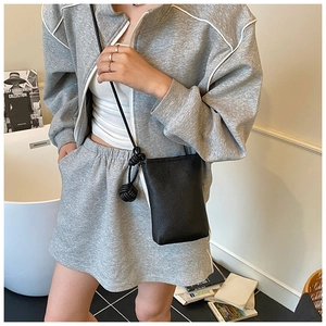 Detail of black pebbled leather crossbody phone bag with stylish knotted shoulder strap