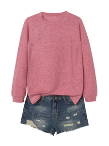 Flat lay of pink heathered long sleeve sweatshirt paired with distressed denim shorts
