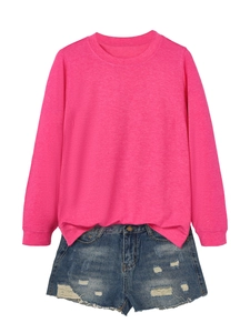 Detail of rose pink crewneck sweatshirt paired with distressed blue denim shorts